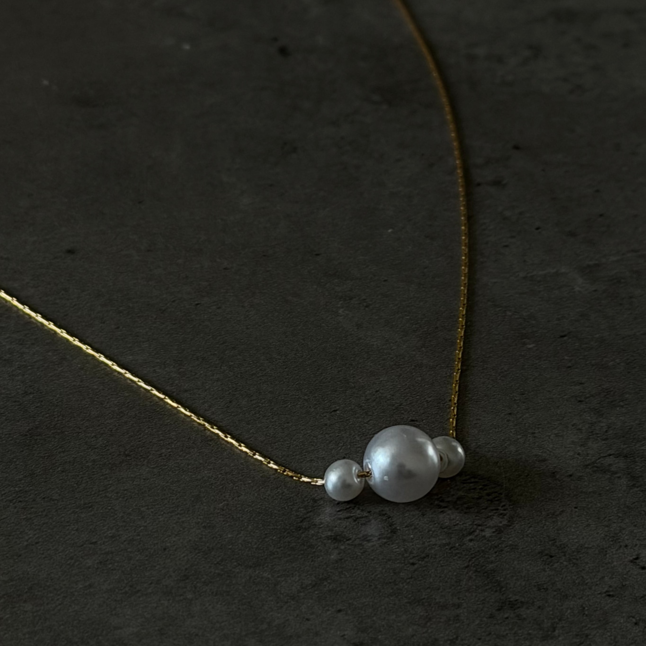 Pearl necklace on a dark textured surface